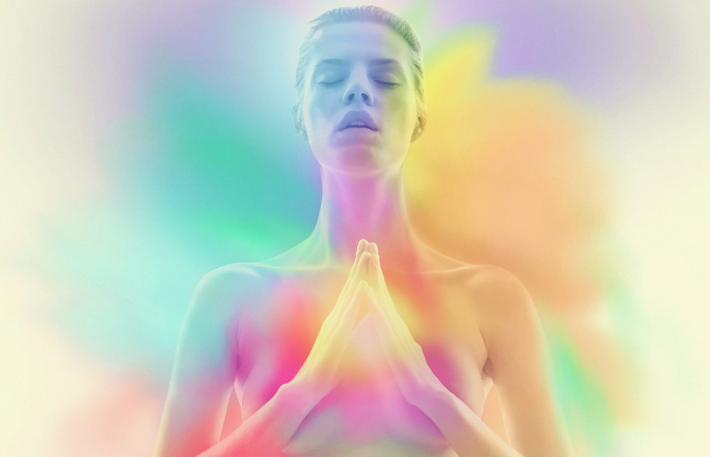 Woman meditating with rainbow aura
